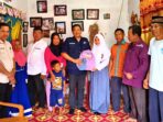 Camat Selangit Misbahuddin Lubis menyerahkan tas sekolah kepada salah seorang siswa sebagai simbol dimulainya penyaluran bantuan perlengkapan sekolah.