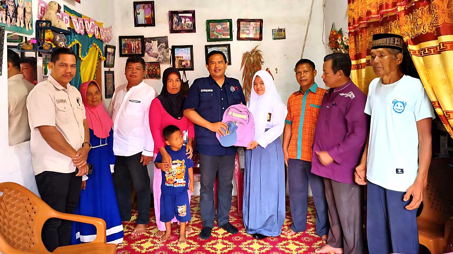 Camat Selangit Misbahuddin Lubis menyerahkan tas sekolah kepada salah seorang siswa sebagai simbol dimulainya penyaluran bantuan perlengkapan sekolah.