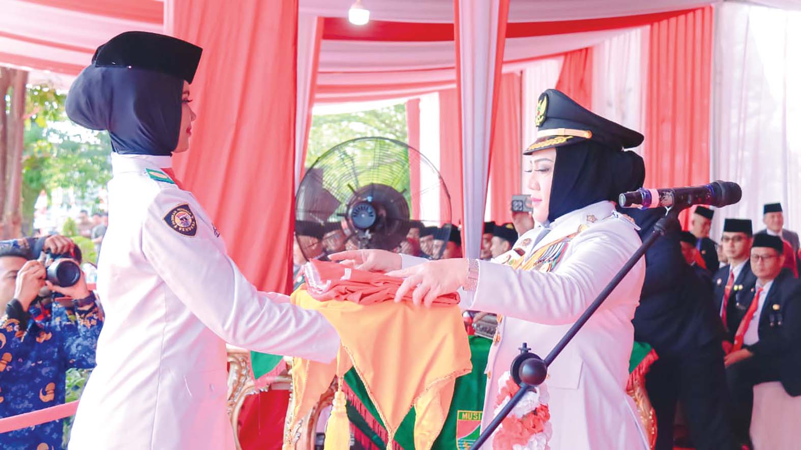 Bupati Musi Rawas, Hj. Ratna Machmud menyerahkan Duplikat Bendera Merah Putih dalam Upacara Peringatan HUT ke-81 Kemerdekaan RI di Kabupaten Musi Rawas, Senin 17 Agustus 2026.