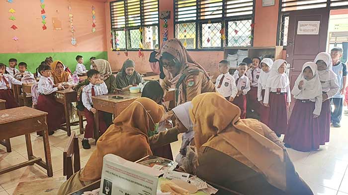 Wali Kelas 1 SDN 16 Lubuk Linggau, Umi Klasum, bersama petugas Puskesmas Sidorejo saat mendampingi pelaksanaan imunisasi vaksin MR kepada siswa kelas 1 di SDN 16 Lubuk Linggau, Senin 3 Agustus 2026. Foto : Mukmin Hidayat/Linggau Pos