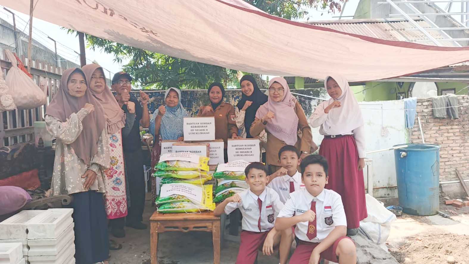 Kepala SDN 8 Lubuk Linggau, Rusmani, bersama guru dan siswa saat menyerahkan bantuan sembako kepada korban kebakaran di Jalan Maluku, Kelurahan Jawa Kanan SS, Selasa 4 Agustus 2026. Foto: Mukmin Hidayat/Linggau Pos