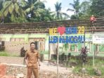 Kepala SDN 29 Lubuk Linggau, Andi Setiawan berdiri di depan lokasi pembangunan ruang kelas yang tengah direvitalisasi atau diperbaiki melalui bantuan pemerintah pusat. Foto: Mukmin Hidayat/Linggau Pos