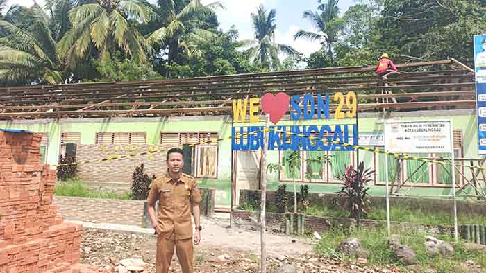Kepala SDN 29 Lubuk Linggau, Andi Setiawan berdiri di depan lokasi pembangunan ruang kelas yang tengah direvitalisasi atau diperbaiki melalui bantuan pemerintah pusat. Foto: Mukmin Hidayat/Linggau Pos